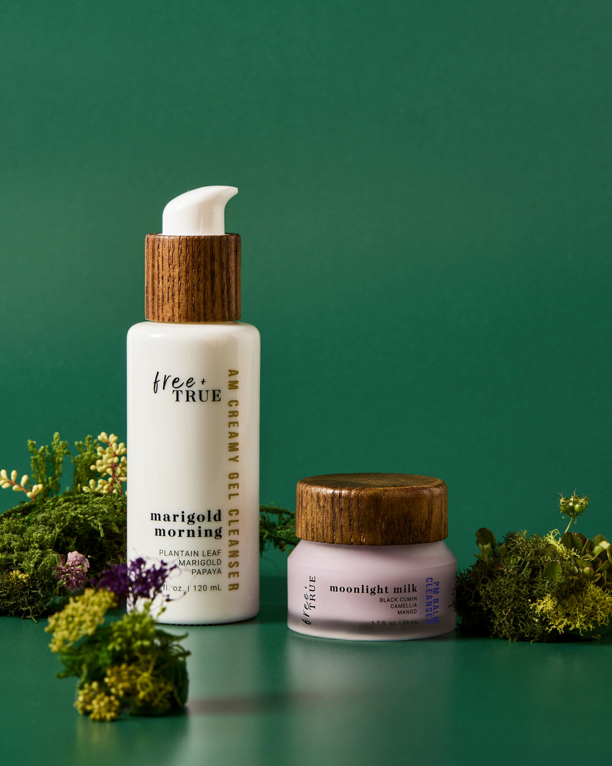 Marigold Morning gel cleanser and Moonlight Milk balm cleanser side by side on moss